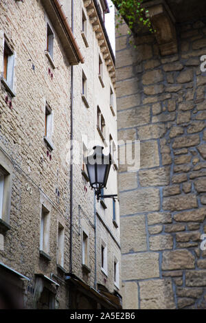 San Marino medieval street, old vintage lantern on the walls. Medieval walls from bricks and stones. Stock Photo