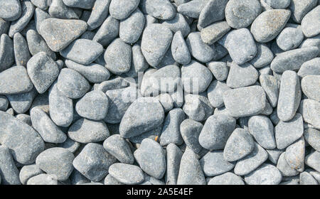 background of gray rounded stones seen from above with daylight Stock Photo