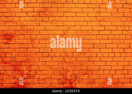 Orange painted brick wall splashed with red paint. Stock Photo