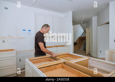 Man using tape measure for measuring on kitchen in furniture for home improvement. Stock Photo