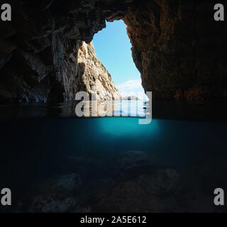 Under a rocky natural arch on the shore of the Mediterranean sea, split view over and underwater, Spain, Costa Brava, Catalonia, Palamos Stock Photo