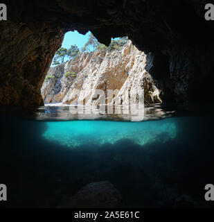 Sea cave on rocky shore, split view over and underwater, Mediterranean, Spain, Costa Brava, Catalonia, Palamos, Cala Foradada Stock Photo