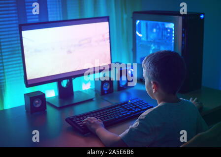 Kid playgame on gaming PC. Concept of growth gaming industry and the mental development of young people. Stock Photo