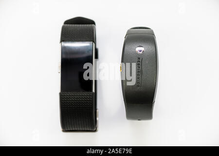 A Philips Respironics Actiwatch and a Fitbit Charge 2. Clinical vs commercial activity tracker watch for insomnia, sleep studies and monitoring. Stock Photo