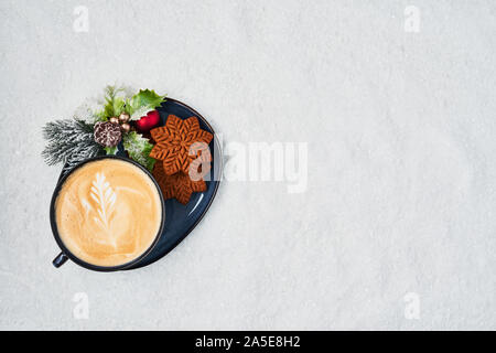 Gingerbread cookies with cappuccino on snow. Top view of traditional Christmas gingerbread cookies. Copy space. Stock Photo