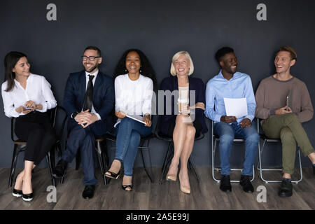 Happy multiracial businesspeople group sit on chairs laughing, human resource Stock Photo