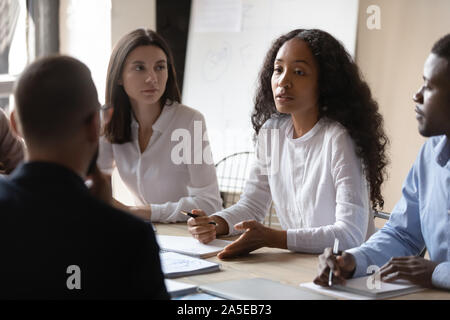Young african businesswoman mentor teaching multiracial people during group briefing Stock Photo