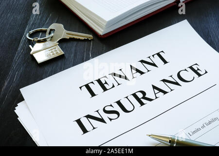 Tenant insurance policy, key and pen for signing. Stock Photo