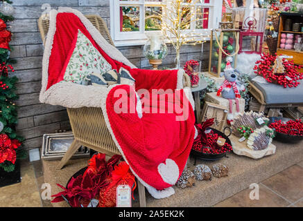 Festive display of Christmas goods and soft furnishings in red white and green in a store UK Stock Photo