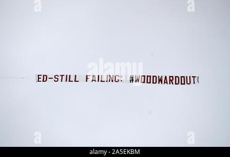 A plane flies over the stadium with a banner aimed at Manchester United chief executive Ed Woodward before the Premier League match at Old Trafford, Manchester. Stock Photo