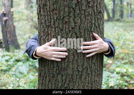 woman wraps her arm around a tree Stock Photo