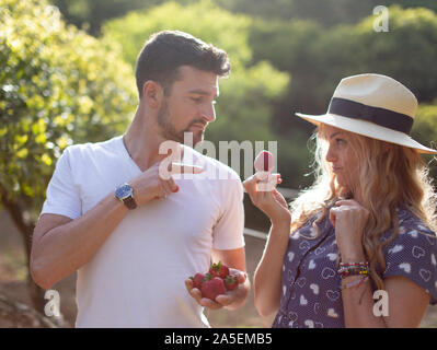 Young vivacious Caucasian couple joking on picnic in nature Stock Photo
