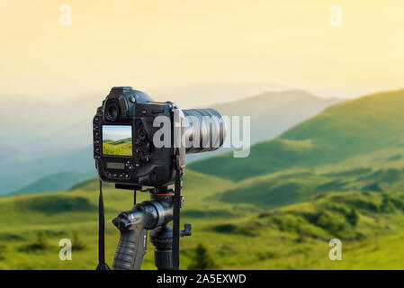 Modern camera on tripod photographs the landscape. Stock Photo
