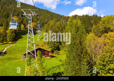 Grindelwald, Switzerland aerial village view, cable car First and autumn Swiss Alps mountains panorama landscape, wooden chalets on green fields, Bern Stock Photo