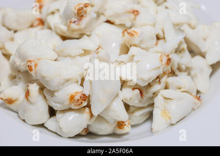 Close up view of pile of fresh steamed crab meat without shell and ready to eat on white dish. Stock Photo
