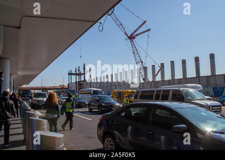 Laguardia Airport, New York, USA- October 14, 2019 - construction cranes working as passengers get into vehicles and cabs at Laguardia airport in New Stock Photo