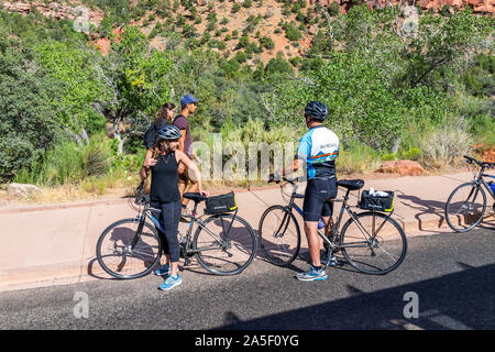 Springdale, USA - August 6, 2019: Zion National Park road in Utah with high angle view of people riding bicycles by sidewalk path Stock Photo