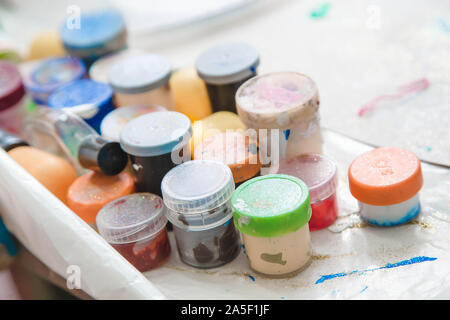 a lot of gouache paint in small jars. means for drawing. school art supplies Stock Photo