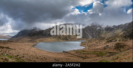 Stunning dramatic Winter landscape image of Llyn Idwal and snowcapped Glyders Mountain Range in Snowdonia Stock Photo