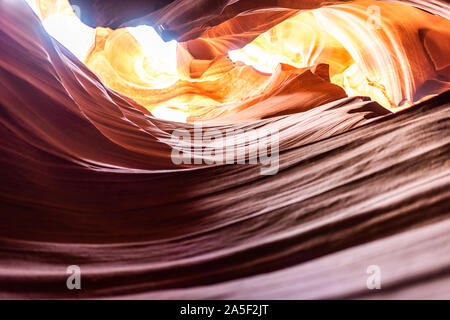 Closeup of texture and view of light sky at upper Antelope slot canyon with red layers of wave shape rock sandstone in Page, Arizona Stock Photo