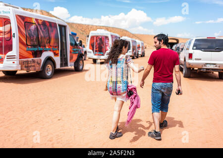 Page, USA - August 10, 2019: Tourist young couple walking by shuttle buses of Navajo tribal Adventurous photo tours at Upper Antelope slot canyon in A Stock Photo