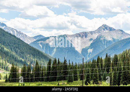 View of mountain peaks and power cables lines near Ouray, Colorado with San Juan rocky mountains in summer from Million Dollar Highway Stock Photo