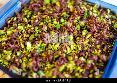 Closeup macro view of homemade pistachio chocolate raw vegan cake with chocolate shavings and nut green pieces texture Stock Photo