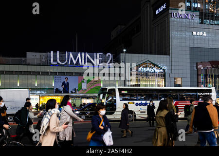 Shinjuku, Japan - March 28, 2019: Large shopping center exterior in downtown Tokyo city with many Japanese people on street outside station after work Stock Photo