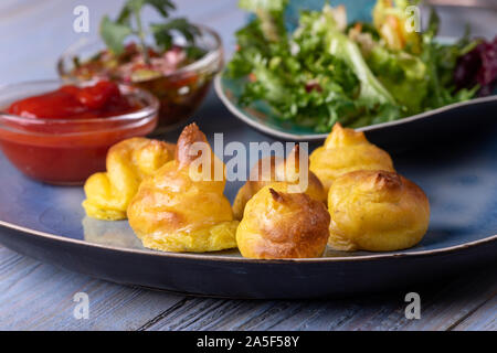 pommes duchesse with salad on a plate Stock Photo