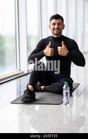 Sporty man resting, having break drinking water after doing exercise. Stock Photo