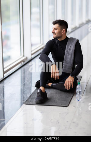 Sporty man resting, having break drinking water after doing exercise. Stock Photo