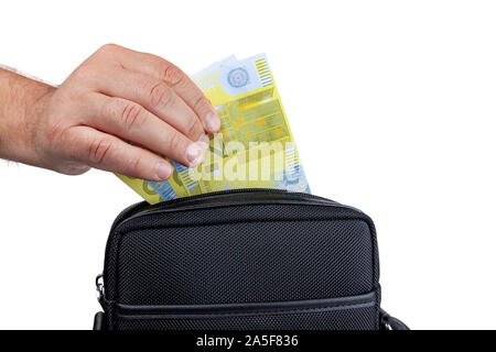 The hand pulls out, puts the money in the bag. Stock Photo