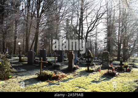 Sunrays glowing in graveyard during sunset Stock Photo