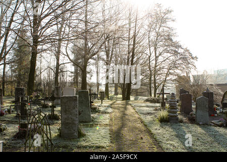 Sunrays glowing in graveyard during sunset Stock Photo