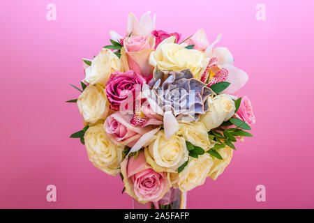 Roses in a brides flower bouquet on pink wall background behind Stock Photo