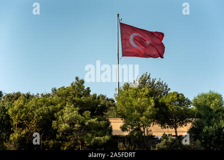 National flag of Turkey on top of the hill against the clear blue sky Stock Photo