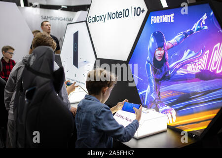 POZNAN, POLAND - October, 19th 2019: Boy is playing Fortnite game on Samsung phone at PGA2019. PGA2019 is a computer games and entertainment event org Stock Photo