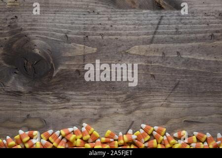 Overhead shot of candy corns in the bottom on a wooden surface great for background writing text Stock Photo