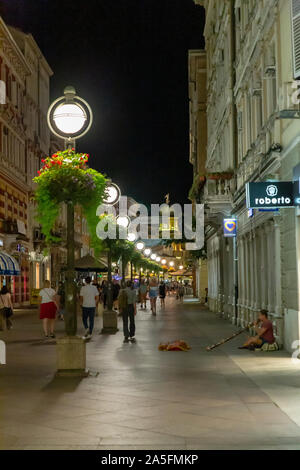 The Korzo shopping street on a summer evening wit a street busker playing a didgeridoo.  Rijeka, Croatia Stock Photo