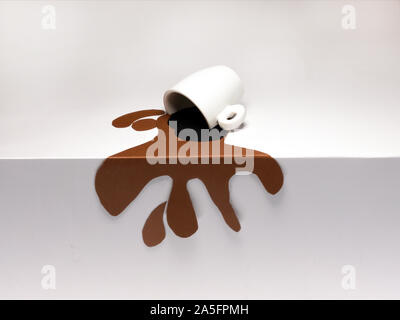 Conceptual cup of spilled coffee on a table Stock Photo