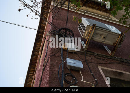 Telephone and communication cables and electrical wires on the facade of the building. Stock Photo