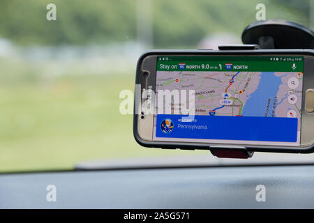 Google maps on a car dashboard with a welcome to Pennsylvania alert Stock Photo