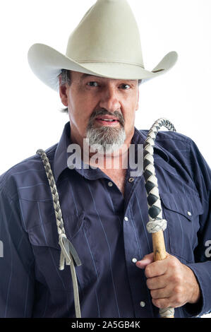 Old cowboy holding a bullwhip over his shoulder Stock Photo