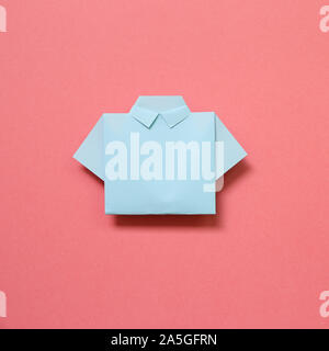 Blue paper shirt origami on pink background Stock Photo