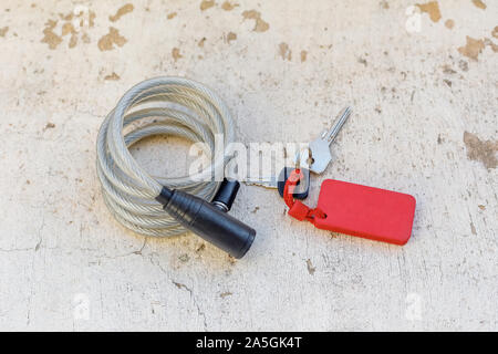 Long bike lock and keys on white wall background Stock Photo