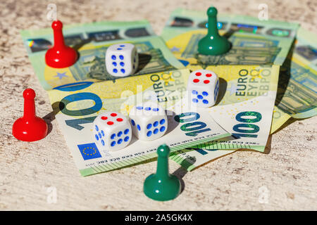 Multi-colored plastic chips, dice of board games with hundredth euro banknotes. Gambling concept Stock Photo