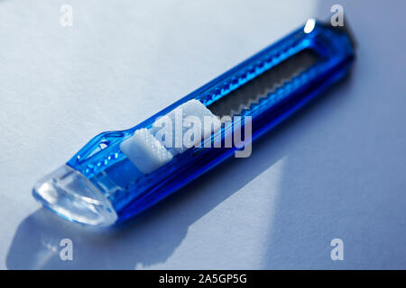 a blue carpet knife in close-up on light surface Stock Photo