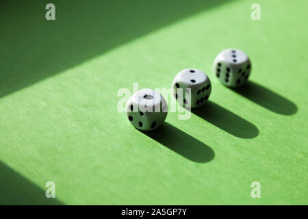 three dice in a row with the numbers one to three on a green background Stock Photo