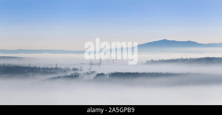 Power transmission towers in a fog, in a mountainous region in southern Yakutia, Russia. Stock Photo