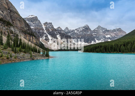Beautiful turquoise water of Moraine lake in foggy moning, Rocky Mountains, Canada. Stock Photo
